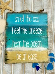 a wooden sign that says smell the sea feel the breeze hear the ocean be at ease