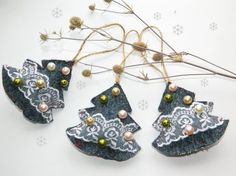 three ornaments are hanging from some twigs on a table with snowflakes in the background