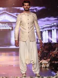 <p><strong>Sherwani:</strong><br />Color: Antique white<br />Fabric: Jamawar<br />Elegant sherwani features rich quality embellishments accent the collar, sleeves and front<br />Fancy button closure</p> <p><strong>Inner:</strong><br />Complement with cream kurta and shalwar</p> <p><br /><br /><strong>Additional Accessories:</strong><br />Kolhapuri/Saleem Shahi shoes: <strong>US$50</strong><br />(Made with sherwani material & embroidery)<br />Tied pre-made Turban: <strong>US$150</strong><br />Men Designer Cream Sherwani With Long Sleeves, Designer Cream Long Sleeve Sherwani, Designer Long Sleeve Cream Sherwani, Designer Cream Kurta For Transitional Season, Designer Cream Bandhgala For Festive Occasions, Cream Long Sleeve Sherwani For Transitional Season, Designer Cream Nehru Jacket, Cream Long Sleeve Sherwani For Reception, Designer Cream Kurta With Dabka Detailing