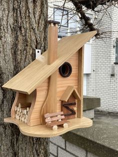 a bird house made out of wood on the side of a tree