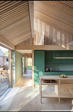 an open kitchen and dining area in a house with wood floors, green walls and ceiling