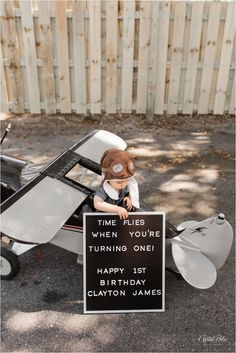 a toy airplane with a sign that says time for when you're turning one happy 1st birthday clatton james