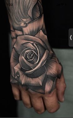 a man's hand with a rose tattoo on it