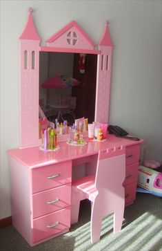 a child's pink vanity and mirror in a room