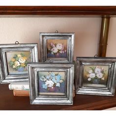 three framed flowers are sitting on a shelf