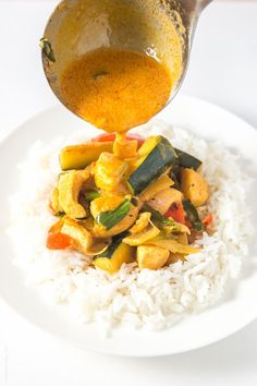 someone is pouring sauce on top of the rice and vegetable stir - fry dish that's ready to be eaten