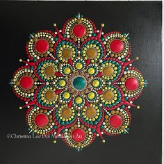 a painting on a black surface with red, yellow and green circles in the center