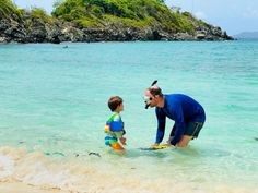 a man standing next to a little boy in the ocean