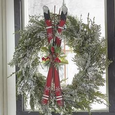 a christmas wreath hanging on the window sill