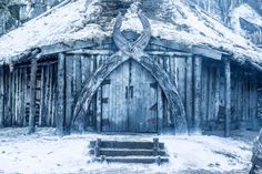 an old wooden building with a large cross on it's door and snow covered roof