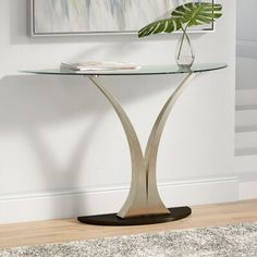 a glass and metal table with a plant on top