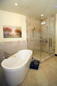 a bathroom with a large tub and walk in shower next to a sink area that has a painting on the wall