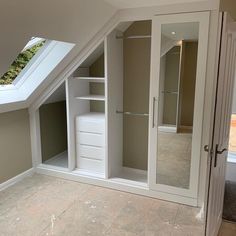 an attic bedroom with white closets and glass doors