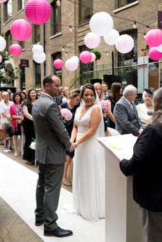 a bride and groom are standing at the alter in front of a crowd of people