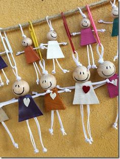 a group of paper dolls hanging on a line with clothes pins attached to the strings