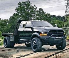 a black truck is parked on the train tracks