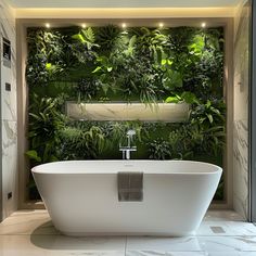 a bathtub in front of a green wall with plants growing on the walls and around it