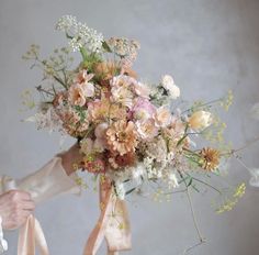 a woman holding a bouquet of flowers in her hands