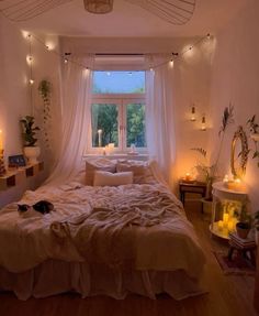 a bed sitting in a bedroom next to a window with candles on the windowsill