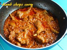 lamb chops curry in a skillet on a blue table with the words lamb chops carry