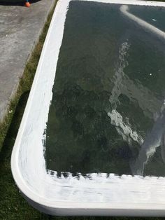 a large rectangular pool with green water in the middle and white paint on it's sides