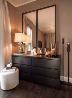 a dresser with candles and a mirror on top