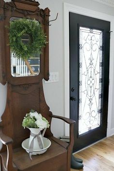 an old wooden chair with a wreath on top of it in front of a door