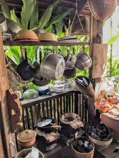 pots and pans are hanging from the ceiling in an outdoor area with wood flooring