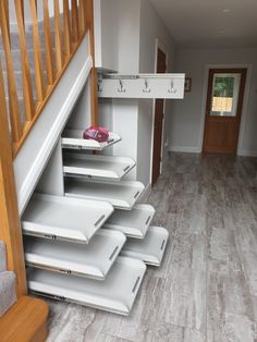 the stairs in this house are made of wood and have white plastic boxes on them