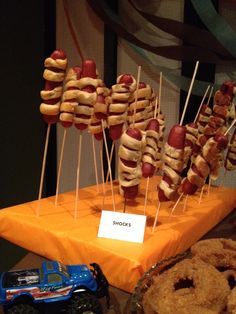 hot dogs on skewers and other food items