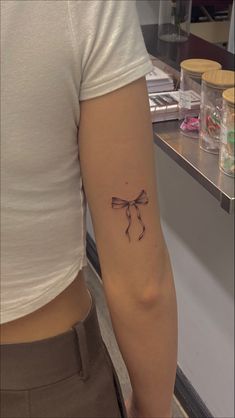 girl with bow tattoo on the back of the arm, bow tattoo, womens fine line tattoo Pink Bow Tattoos, Small Bow Tattoo, Tattoo Lace, Bow Tattoo Designs, Petit Tattoo, Ribbon Tattoos