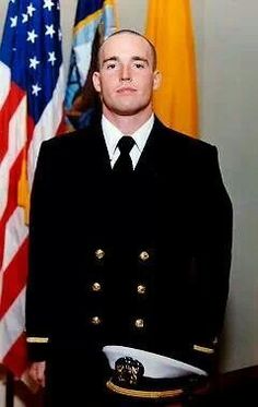 a man in uniform standing next to flags