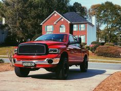 a red ram truck parked in front of a house