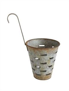 an old metal bucket with a handle and holes on the side, hanging from a hook