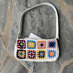 a crocheted purse sitting on top of a stone floor