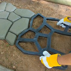 a person wearing yellow and white shoes standing next to a stone walkway with an iron grate on it