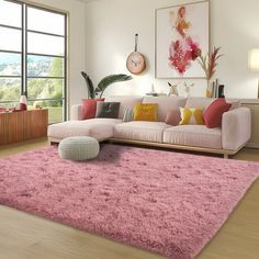 a living room filled with furniture and a pink rug