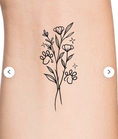 a tattoo on the side of a woman's leg with flowers drawn on it