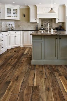 a kitchen with wood floors and white cabinets