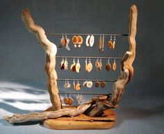 a sculpture made out of driftwood with earrings hanging from it's hooks and chains