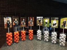 soccer balls and pictures are on sticks in front of the wall