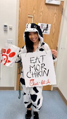 a woman in a cow costume holding up a sign