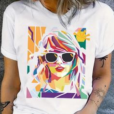 Show Off Your Love For Taylor Swift With This Stylish Graphic T-Shirt. The White Color And Regular Size Make It A Versatile Addition To Any Wardrobe, While The Unique Design Adds A Touch Of Personality. Perfect For Any Fan Or Fashion Enthusiast, This T-Shirt Is A Must-Have For Your Collection. Whether You're Going To A Concert, Running Errands, Or Hanging Out With Friends, This Shirt Is Sure To Make A Statement. Fun Graphic Design Tops For Spring, Fun Spring Graphic Design Tops, Fun Graphic Design Tops, White Graphic Tops With Fun Design, Fun White Tops With Graphic Design, White Fun Tops With Graphic Design, Multicolor Graphic Tops For Summer, Multicolor Graphic Design Tops For Summer, Fun Summer Tops With Graphic Design