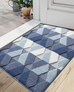 a blue and white rug sitting on top of a wooden floor next to a door