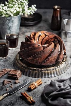 a bundt cake sitting on top of a table next to some cinnamons and coffee