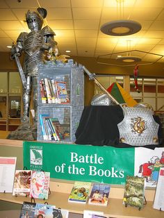 there is a display in the library with books on it and a statue of a knight