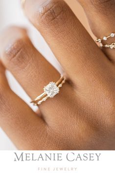 a woman's hand with two rings on it and the words melanie casey fine jewelry