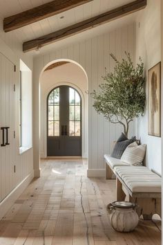 an entryway with a bench, potted plant and pictures on the wall