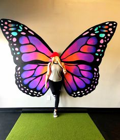 a woman standing next to a giant butterfly