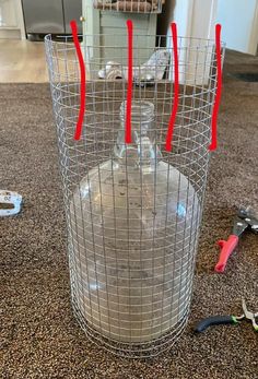 a wire vase with red markers on it